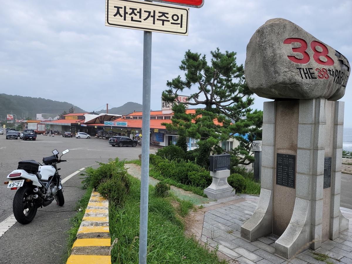 38度線のモニュメントとオートバイの写真