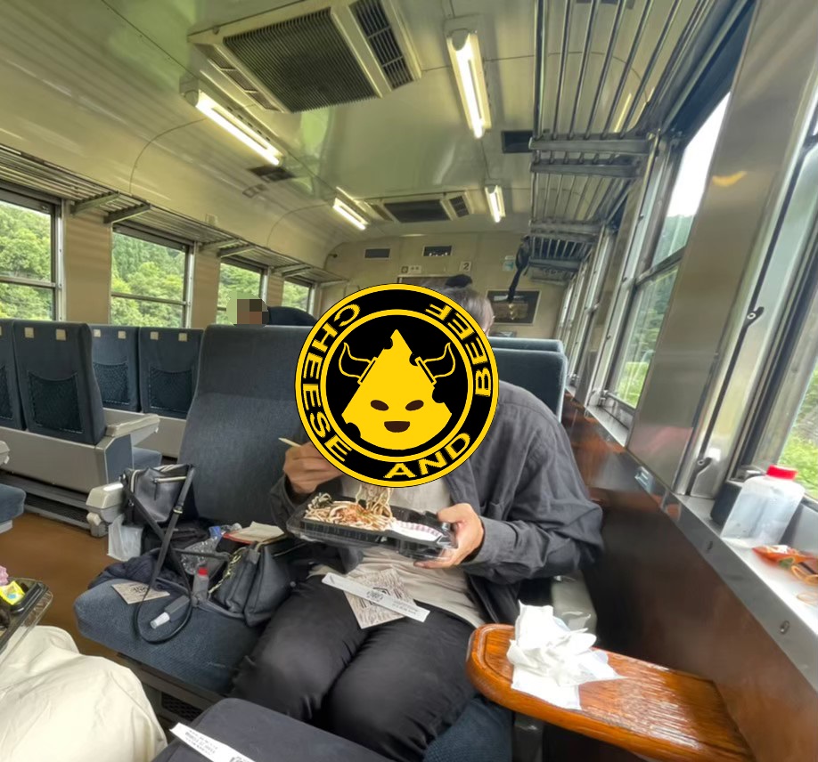 奥出雲おろち号の車内で蕎麦を食べる男性