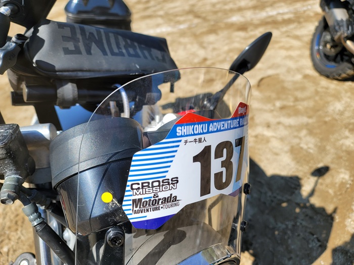 スクリーンに四国アドベンチャーラリーのゼッケンを付けたオートバイ